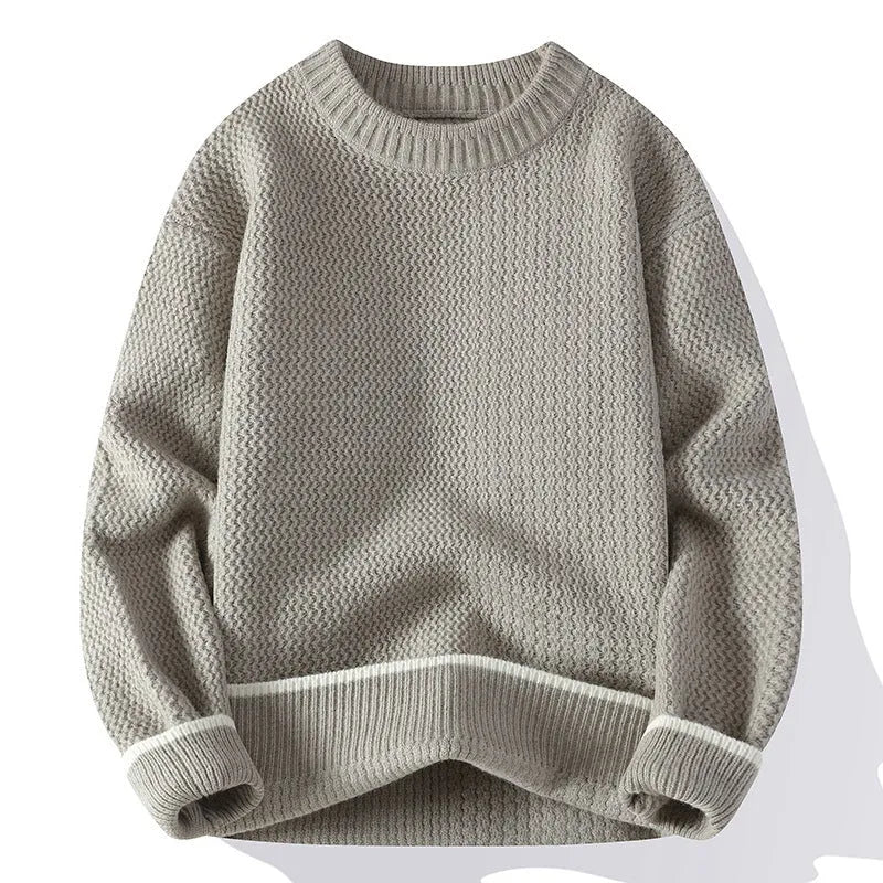 Man wearing a grey loose fit round neck long sleeve pullover sweater