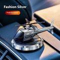 Silver metal solar-powered rotating helicopter car air freshener ornament on a dashboard.