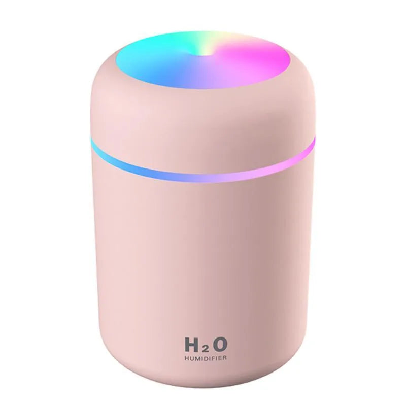 Pink, white, and navy blue USB-powered mini desktop humidifier with water tank and mist spray.