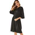 A woman wearing a red mid-length A-line cardigan dress with an elasticated waist and long sleeves.
