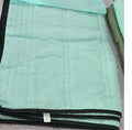 Plain colour seersucker summer cooling quilt shown in light pink on a bed.