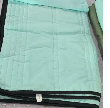 Plain colour seersucker summer cooling quilt shown in light pink on a bed.