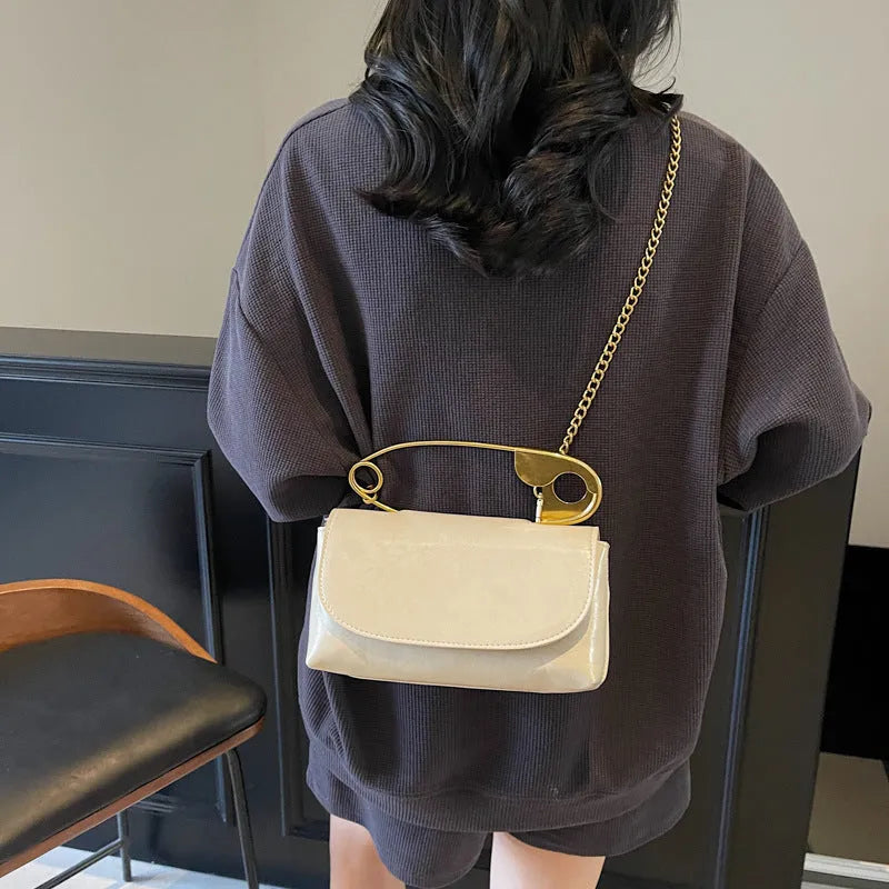 Creative Personality PU paper clip shoulder handbag in a horizontal square shape.