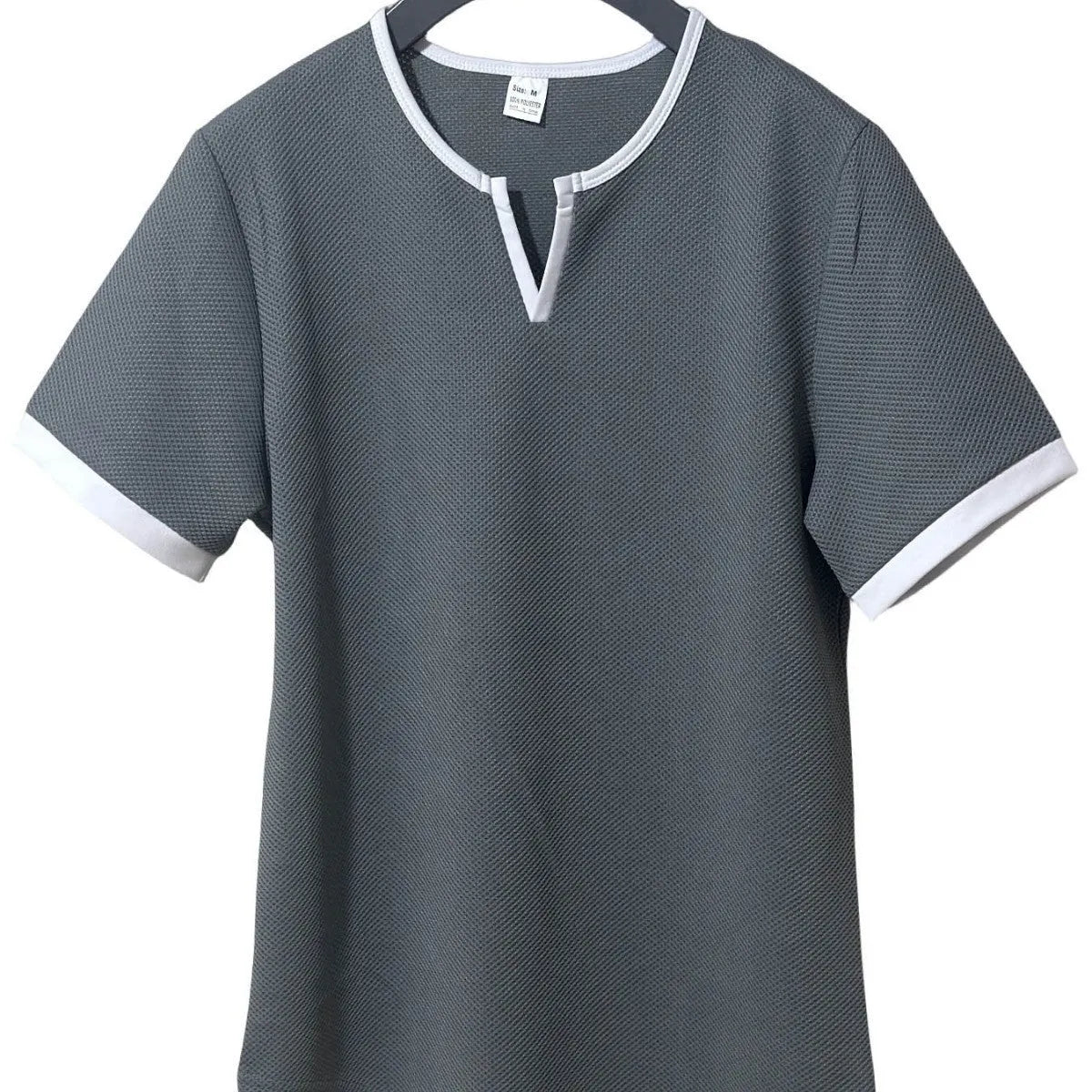 Man wearing a grey and white colour-block V-neck waffle knit short sleeve T-shirt.