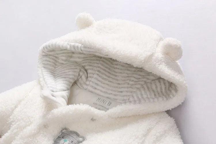 Baby wearing a white cotton padded lamb jumpsuit for winter