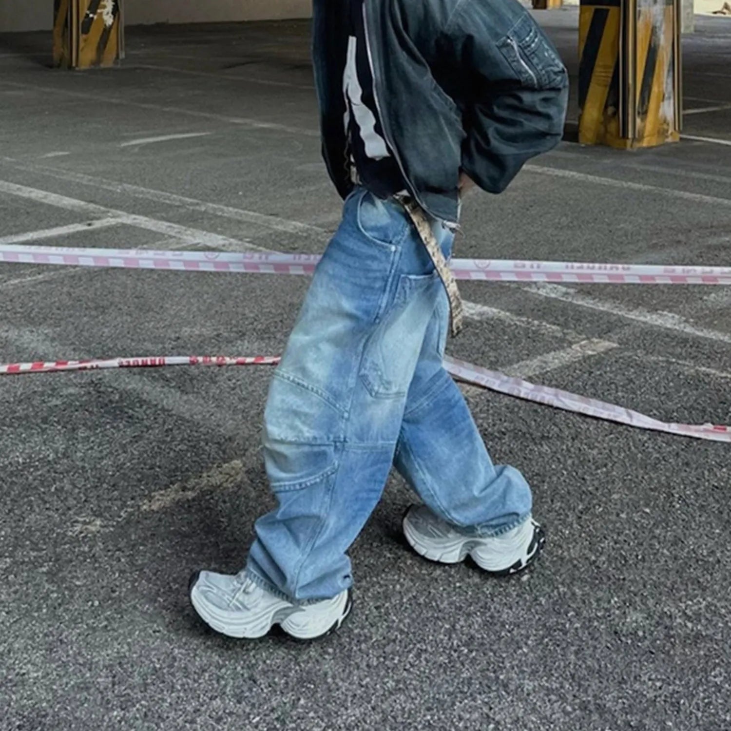 Men's blue white washed denim jeans with baggy cut and straight-leg design showing profile pleating details