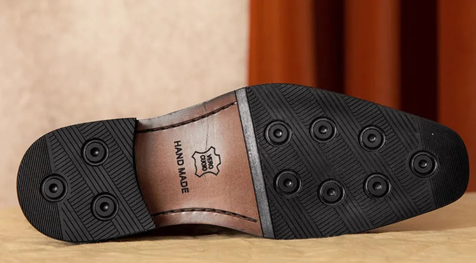 Men's black genuine leather loafers with fringe detail and a rubber sole, shown from a side angle.