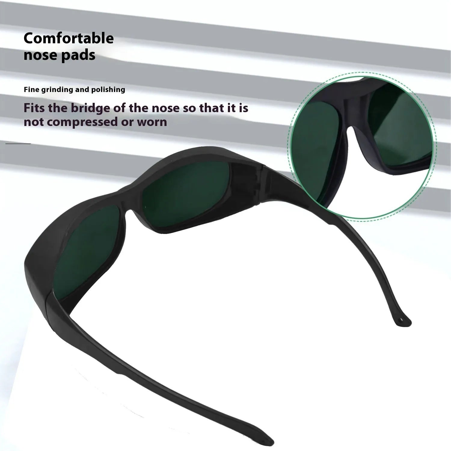 A pair of clear laser and welding safety goggles with a soft cleaning cloth on a dark background.