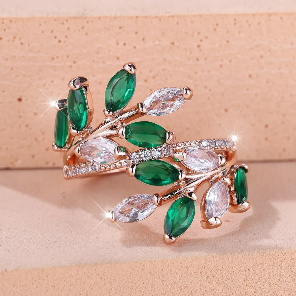 Adjustable copper leaf-shaped ring with zircon stone accents on a hand.