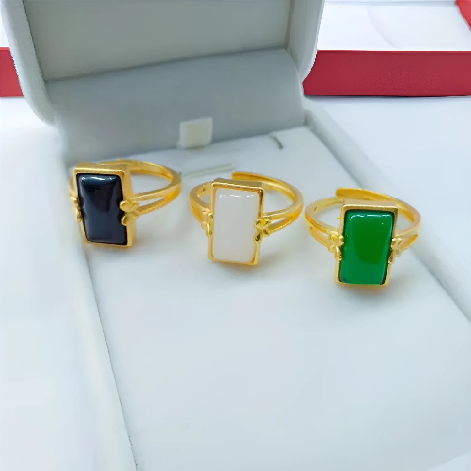 A gold-plated brass ring with an adjustable band and a central green artificial gemstone, in a national style.