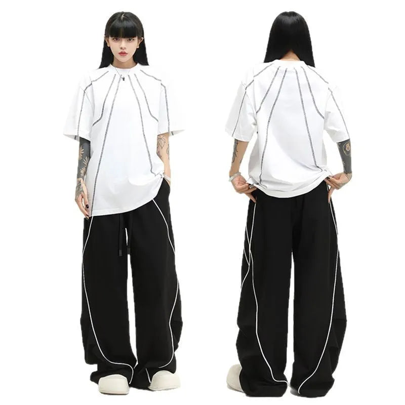 Black striped wide-leg sports pants with pleated detail on a mid-waist, loose fit.