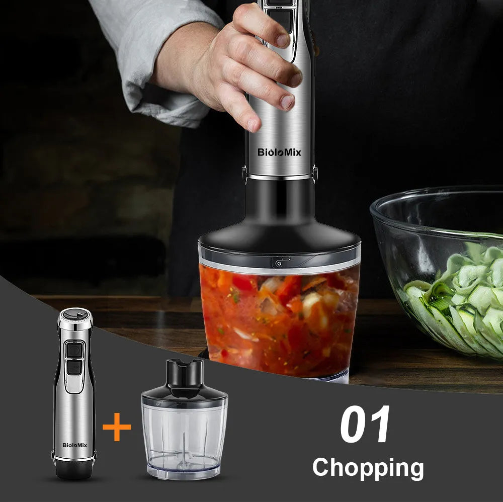 Silver and black Biolomix hand blender set with motor, stainless steel shaft, whisk, chopper bowl, and blending beaker on a kitchen counter.