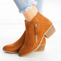 Women's blue suede ankle boots with side zip and chunky heel on wooden floor