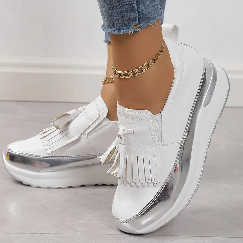 Women's black casual platform shoes with a muffin wedge heel and a decorative tassel.