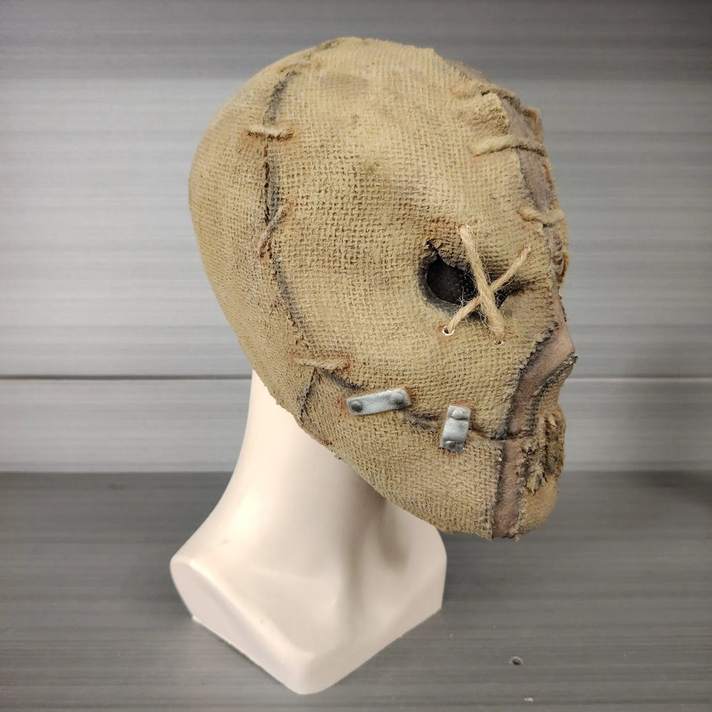 Latex Halloween horror mask with detailed scar skull design on a white background.