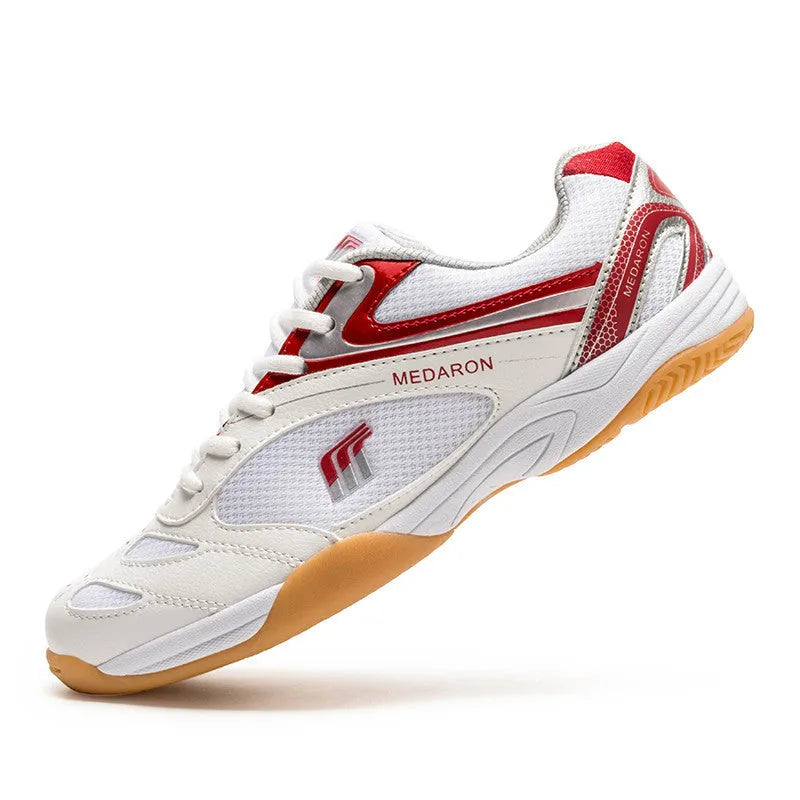 White and blue table tennis sneakers with synthetic leather upper and rubber sole on a court surface.