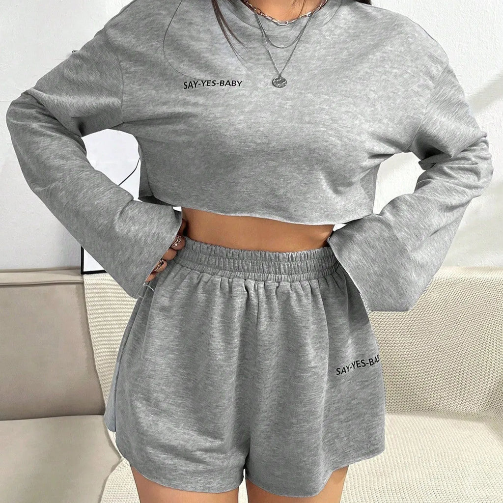 Grey women's polyester tracksuit set with long sleeve t-shirt and matching shorts laid flat.