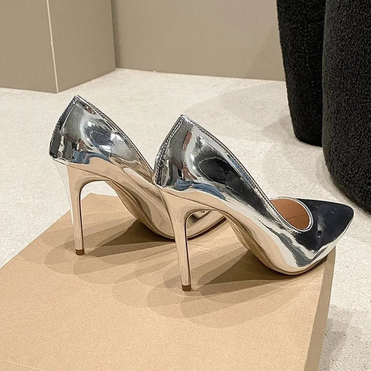 Gold pointed toe slip-on stiletto heel shoe on a white background.