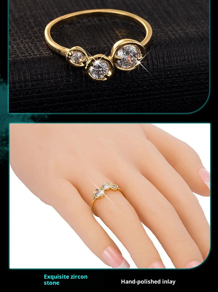 Three copper electroplated rings with lotus leaf design and round zircon stones in gold white zirconium tone on a flat surface
