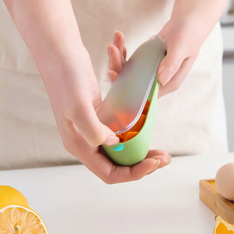 Green plastic peeler with a stainless steel blade stored inside its own clear storage tube, showing the hanging hole on the handle.
