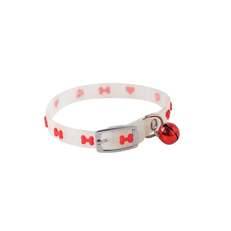 Glowing adjustable cat collar with metal bell in paw print design on black background