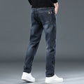 Blue grey slim straight loose casual trousers on a hanger, showing mid waist and zipper fly.