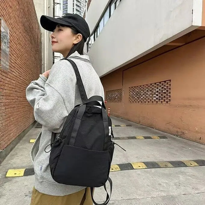 Solid colour nylon backpack with curved shoulder straps and lock details in multiple colour options
