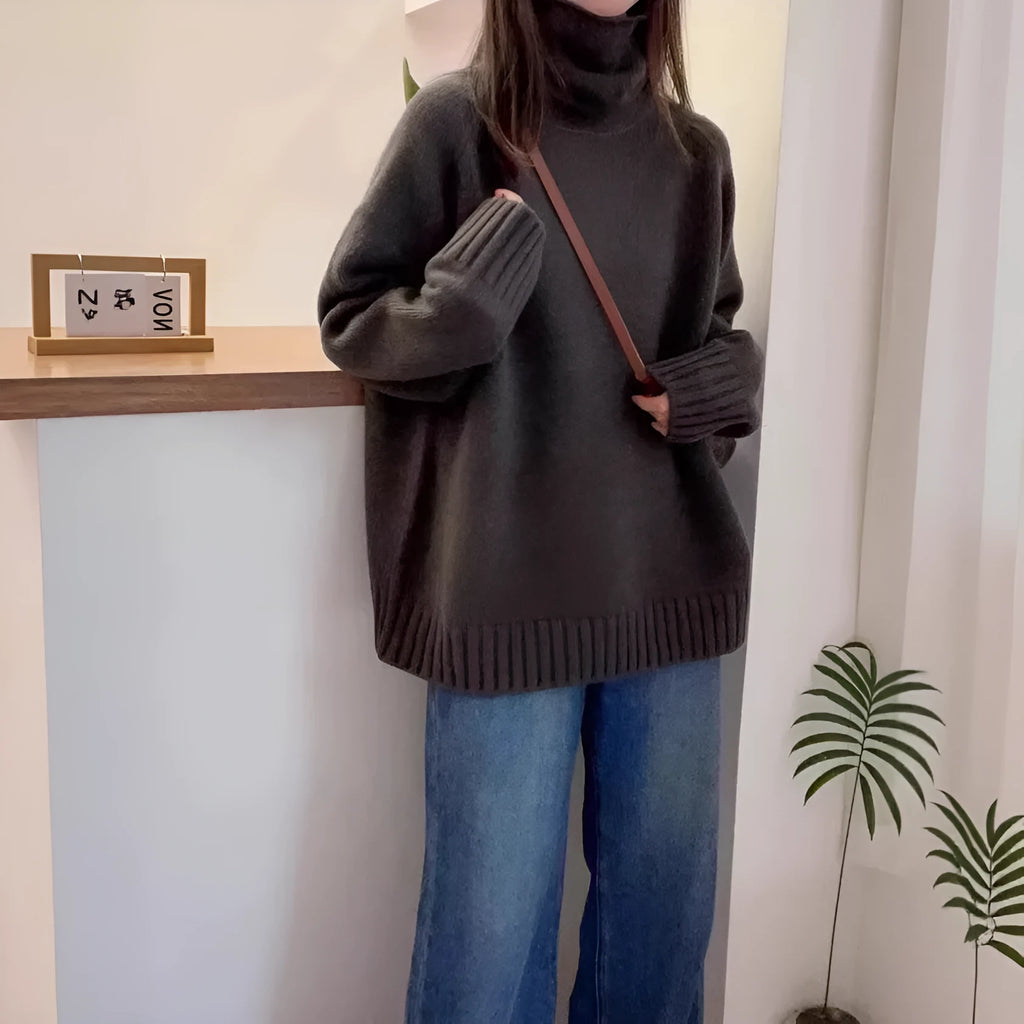 Women's loose grey turtleneck sweater with a textured curling collar and 3D pattern detail.