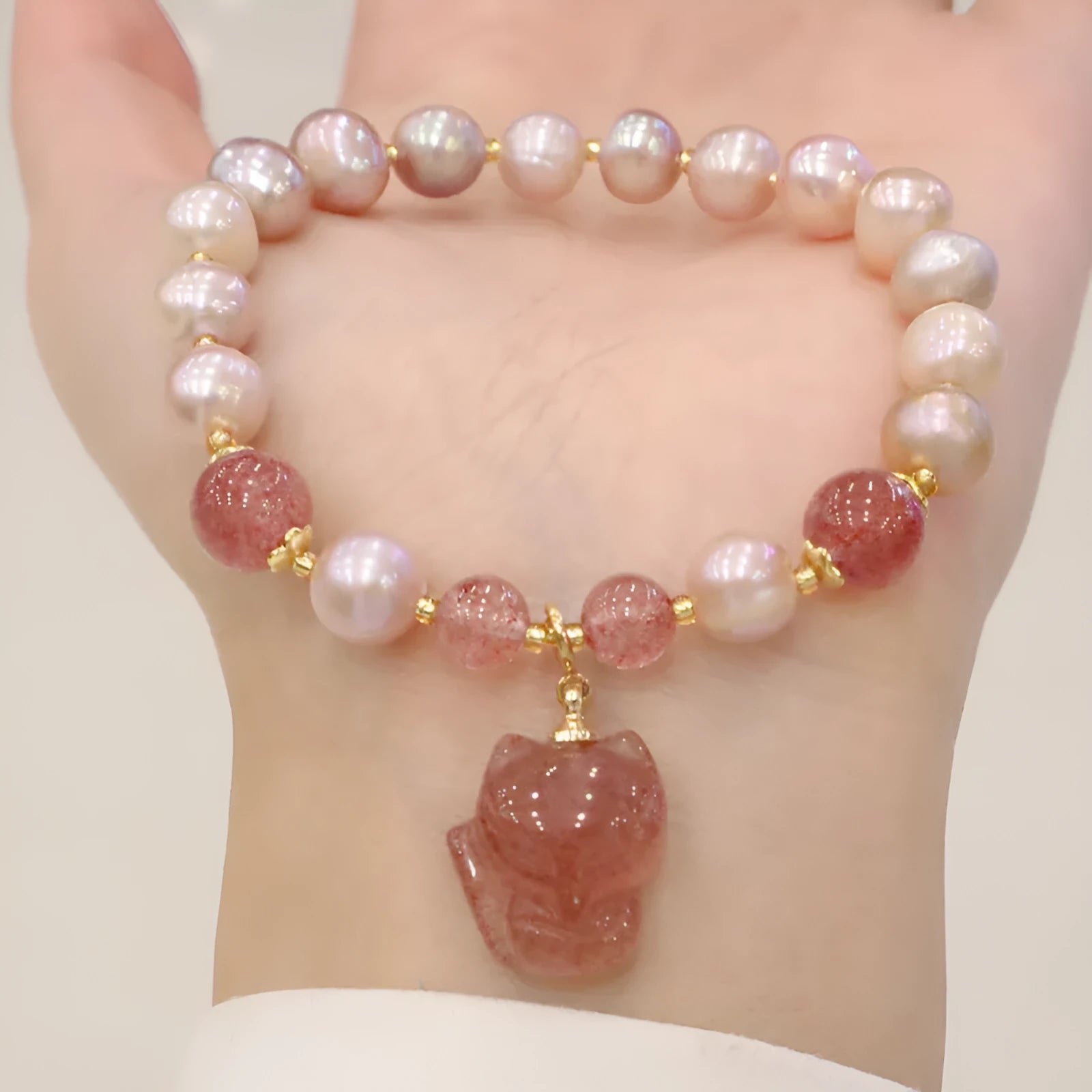 Light pink women's freshwater pearl bracelet with strawberry quartz stones and fox charm
