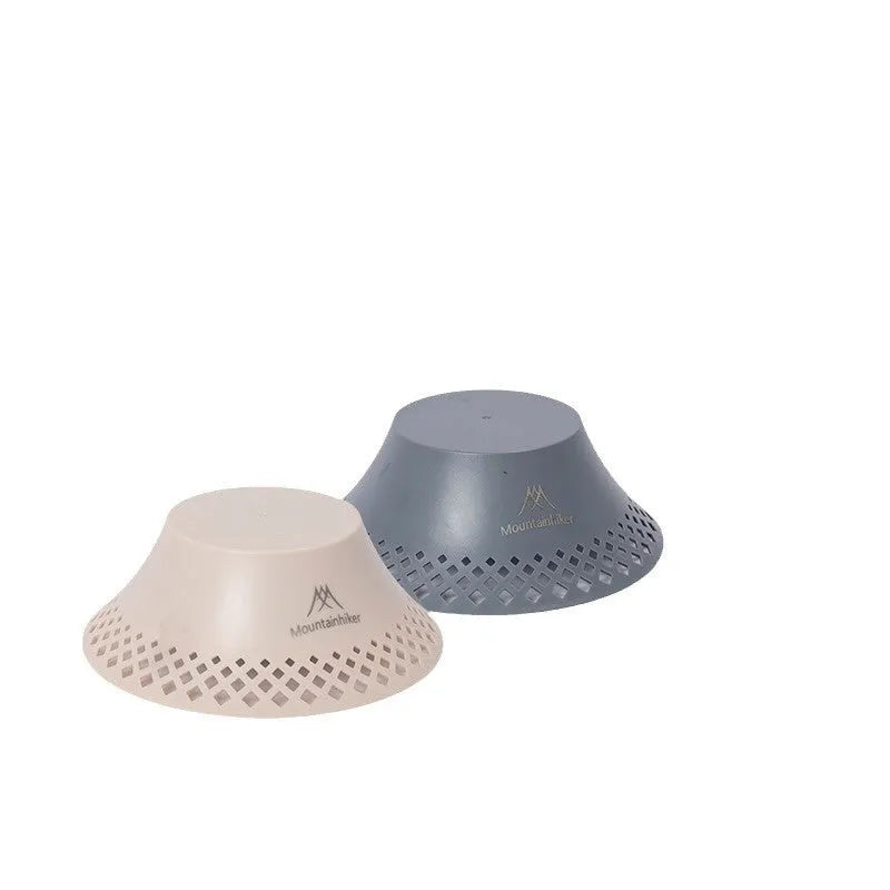 Beige and grey wine bottle-shaped camping lantern with USB-C port on a wooden table.