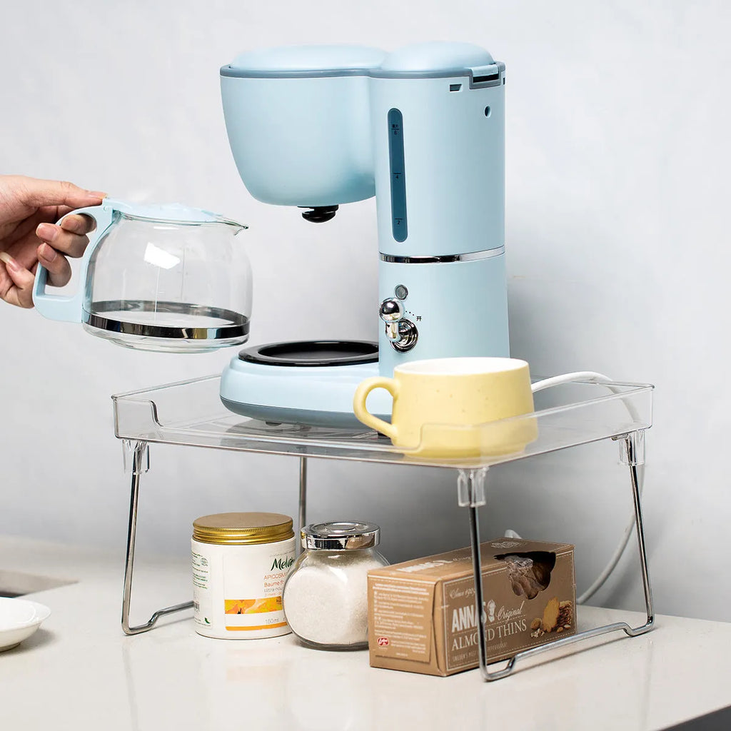 White plastic kitchen supplies rack on a countertop holding spice jars.