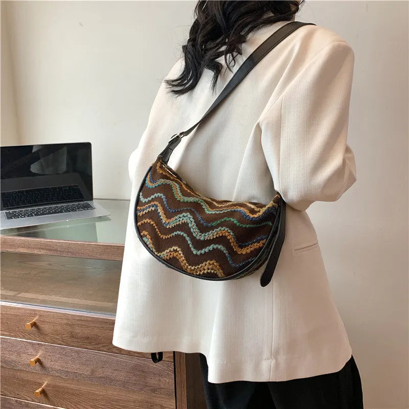 Women's woven straw crossbody bag showing textured surface with phone and file compartments inside