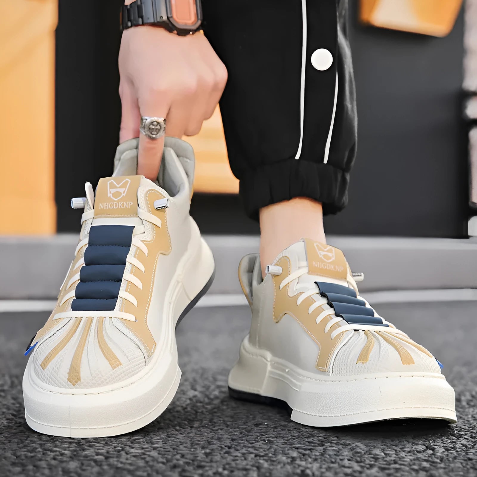 Men's beige low-top slip-on sneakers with elastic band and round toe on a plain background.