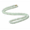 Natural white-green jade bead necklace with adjustable chain and 6.5mm round beads on grey background