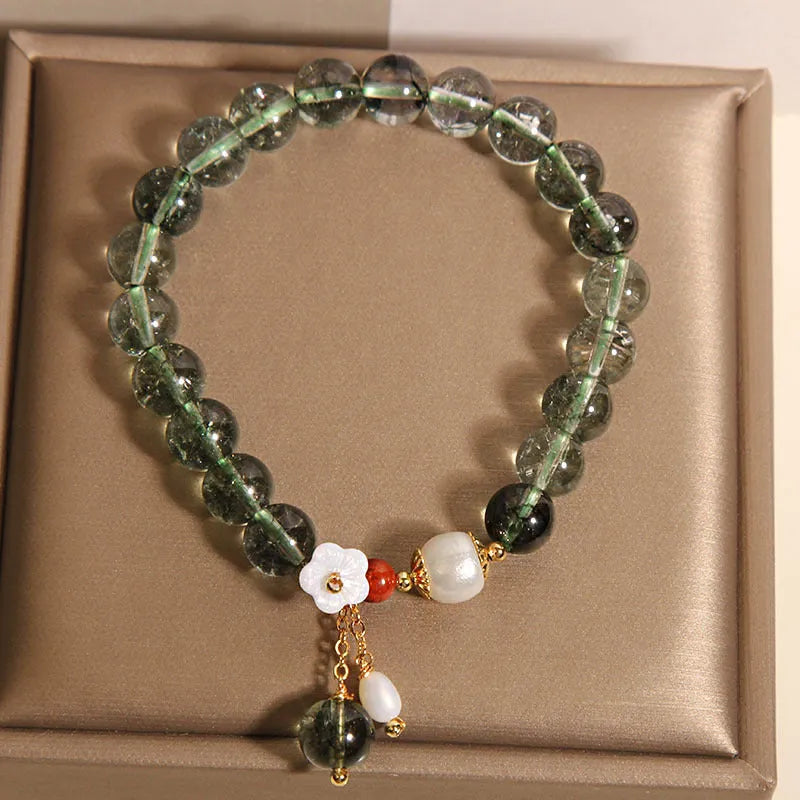 Green phantom quartz crystal bracelet with shell flower charms on wrist