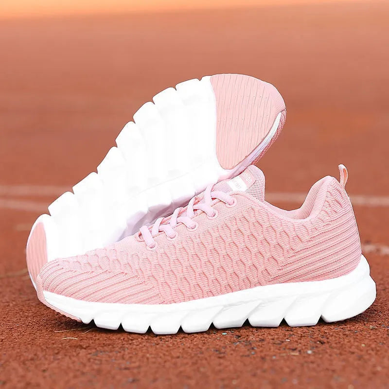 Women's running shoes in black, pink, or white with a fly weave upper and durable outsole.