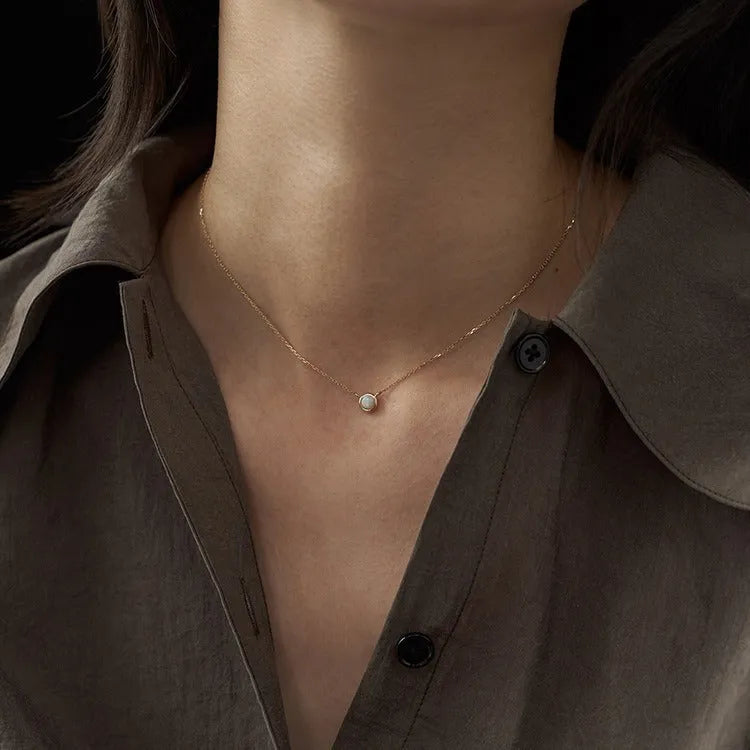 S925 sterling silver necklace with a geometric pendant holding a round jelly opal, plated in gold.
