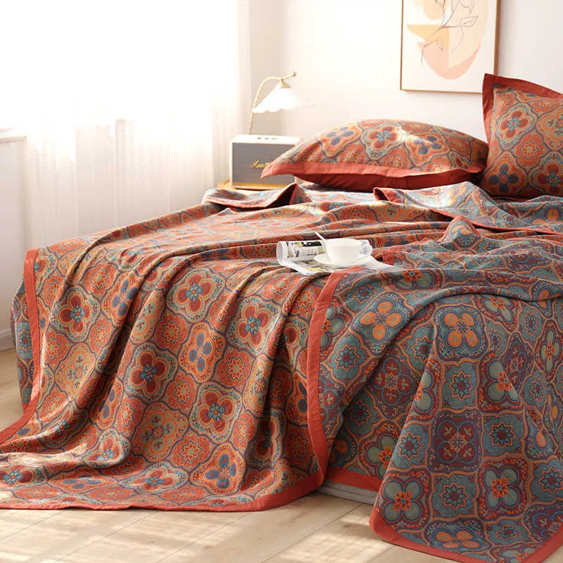 Cotton gauze floral blanket and two matching pillowcases laid out on a bed.