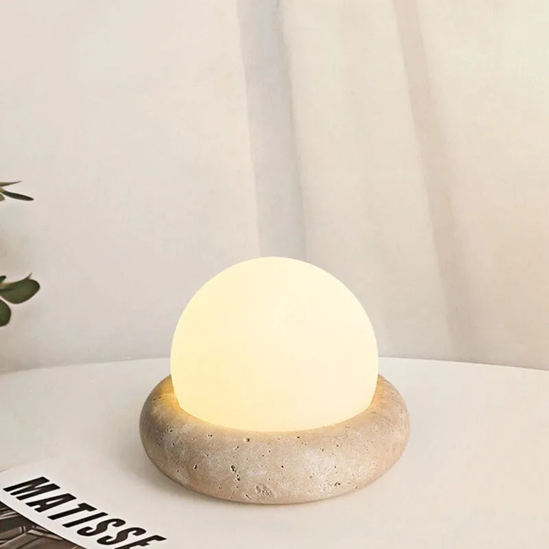 Cream coloured modern bedside night lamp with remote control on wooden table