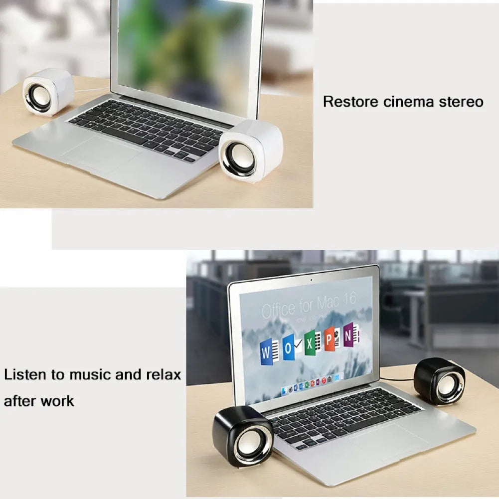 Pair of compact black wired desktop computer speakers with 3.5mm plug next to a laptop.