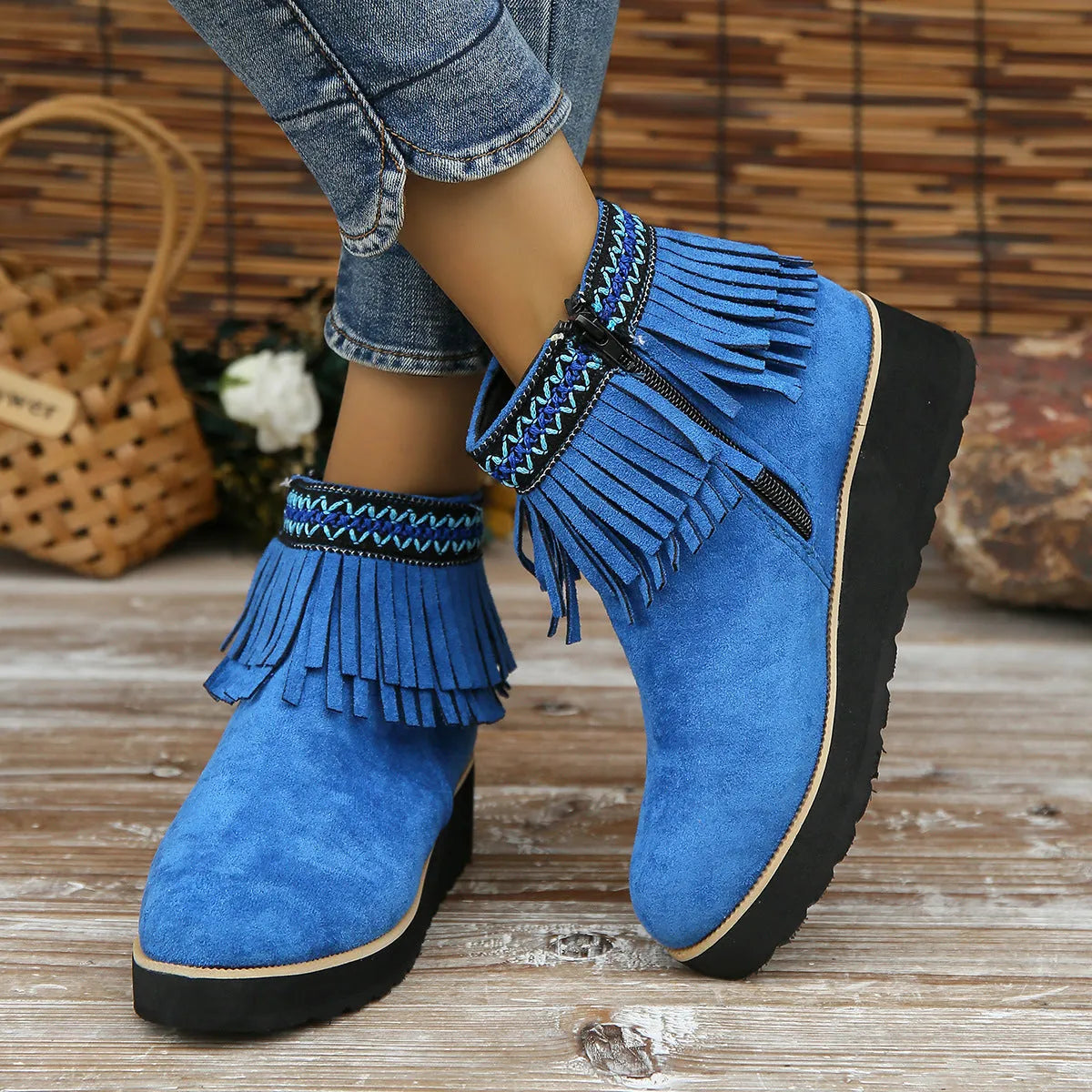 Women's black suede wedge ankle boots with a side zip and tassel detail on a thick rubber sole.
