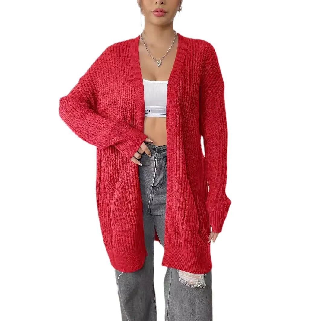 A woman's loose-fit acrylic cardigan in dark green with long sleeves and two front pockets.