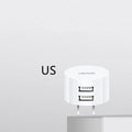 White portable dual USB charger with folding UK, US, and EU plugs showing compact dimensions