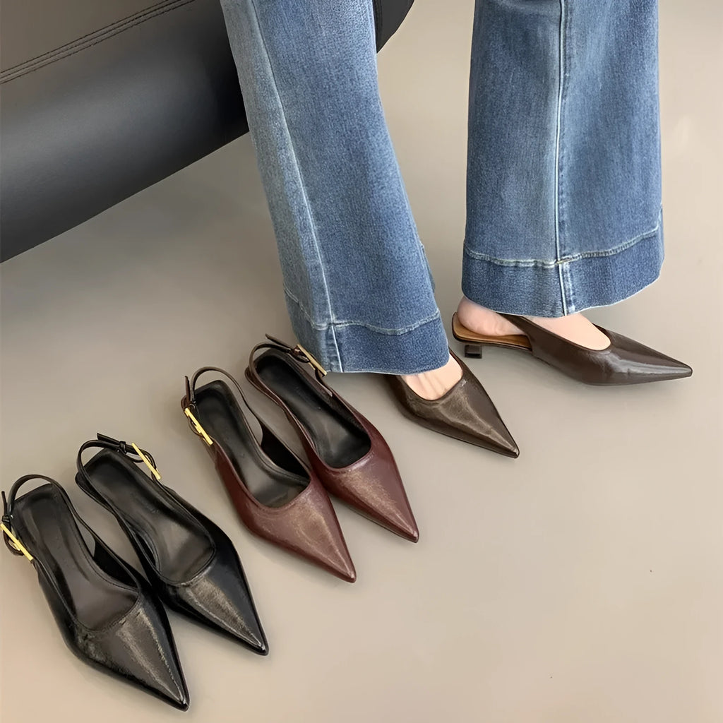 Women's black pointed leather low-heel shoes with thin decorative straps and a rubber sole.