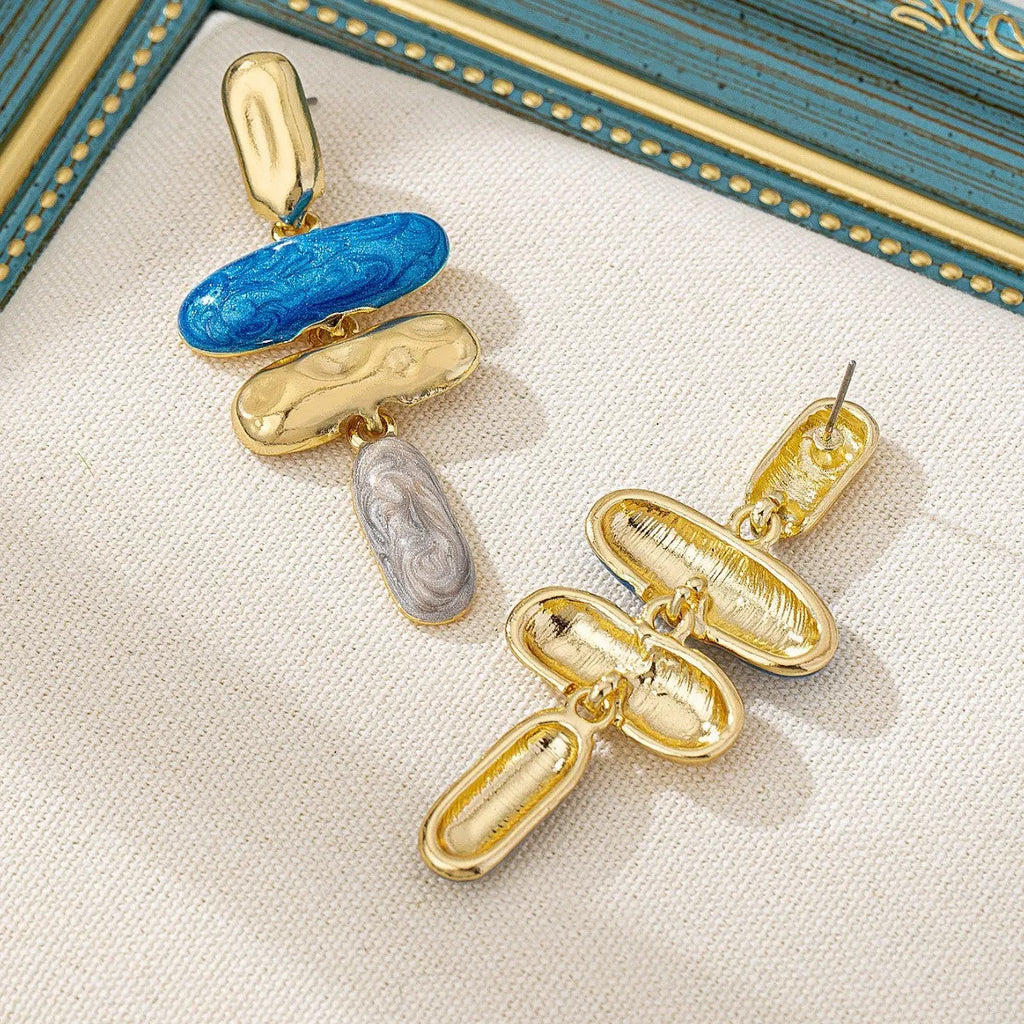 A pair of geometric multicolour stud earrings for women on a plain background.