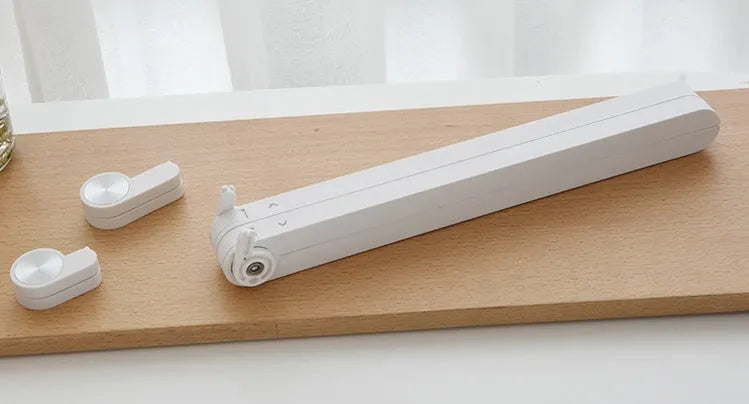 White foldable laptop bracket with heat sink base on a desk.