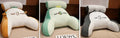 Large fluffy reading cushion with lumbar support in a dinosaur design on a sofa.