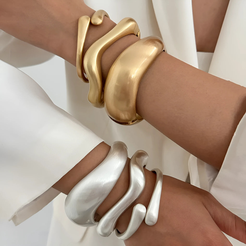 Electroplated alloy opening bracelet with elliptical motif in matte gold finish, cold wind style