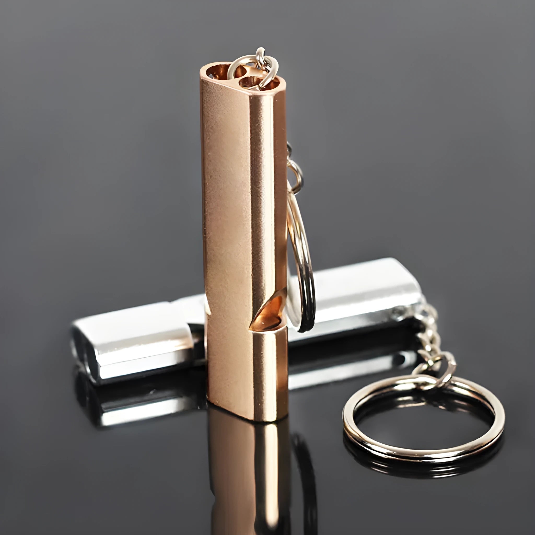 Silver and gold aluminium alloy outdoor survival whistle with double hole design.