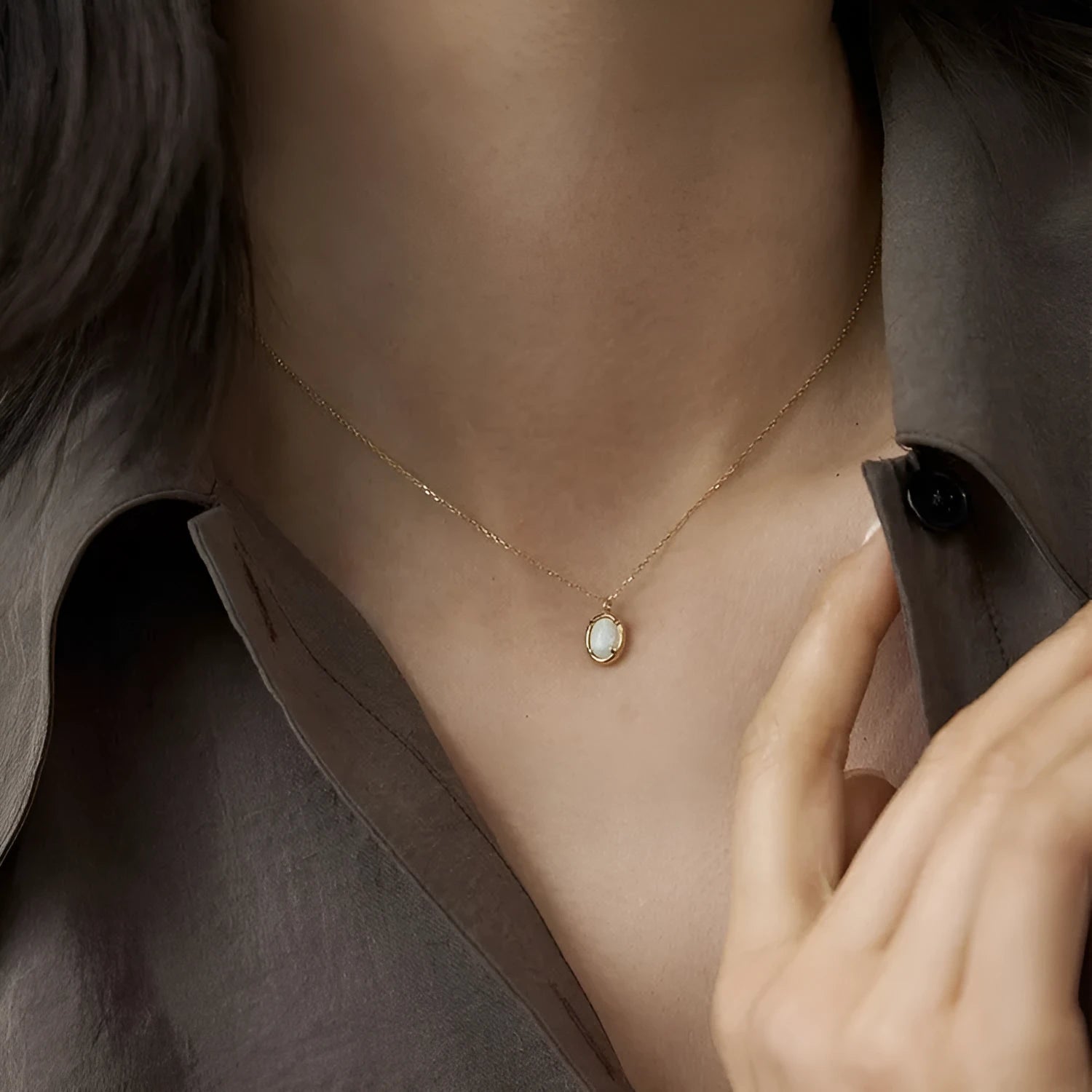S925 sterling silver necklace with a geometric pendant holding a round jelly opal, plated in gold.